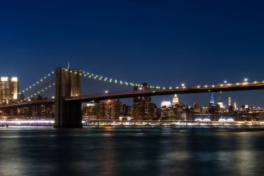 Brooklyn Köprüsü 'nün göz kamaştırıcı manzarası Manhattan ufuk çizgisini gözler önüne sererek geceleyin aydınlandı. Canlı bir fotoğraf tarzıyla yakalanmış