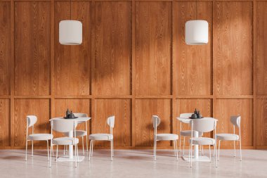 Beyaz sandalyelerin ve masanın bulunduğu, ahşap duvar arkası, çağdaş tasarımı gösteren şık bir yemek alanı. 3B Hazırlama