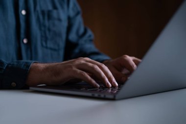 Masada dizüstü bilgisayar kullanan bir iş adamı, masada klavyeye yazı yazan parmaklar. Çevrimiçi alışveriş, web sitesi ve iletişim kavramı, iş dünyası İnternet