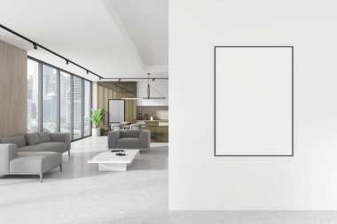 Modern bir oturma odasında beyaz bir duvara asılmış boş bir poster modeli. Gri mobilyaları ve şehir binalarına bakan büyük pencereleri var. 3B Hazırlama