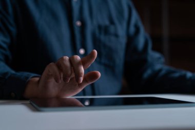 El ve parmak tablet ekranını kapatıp masaya uzanan adamın yan görüntüsü. Mobil uygulama, çevrimiçi alışveriş, sosyal medya, iletişim ve web sitesi kavramı