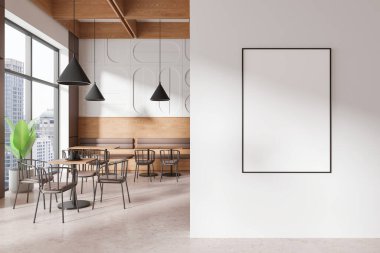 Beyaz bir duvarda boş çerçeveli poster modeli, içinde ahşap mobilyalar ve büyük pencereler bulunan modern bir kafe iç tasarımı var. 3B Hazırlama