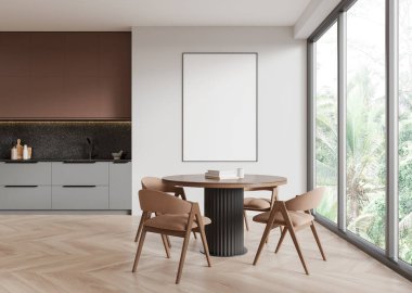 Gri ve kahverengi dolabı, yuvarlak yemek masası ve ahşap zeminde sandalyeleri olan şık bir ev mutfağı. Tropik bölgelerde panoramik pencere. Bölümdeki boş posteri taklit et. 3B görüntüleme