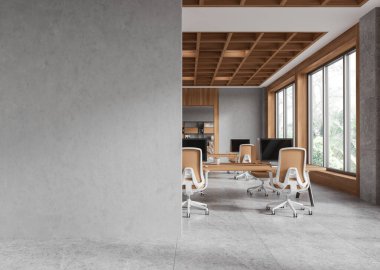 Önünde büyük bir beton duvar olan minimalist ofis, arka planda bilgisayarlar ve sandalyeler olan modern çalışma istasyonları, sakin bir atmosfer. 3B Hazırlama.