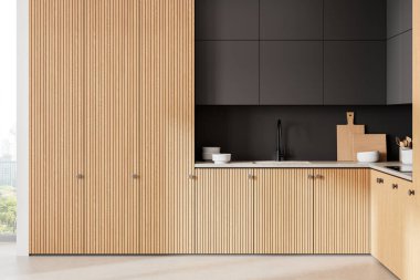 Ahşap panelli dolaplar ve siyah aksanlarla süslü mutfak. Parlak, nötr bir arkaplanda minimalist tasarım. 3B Hazırlama