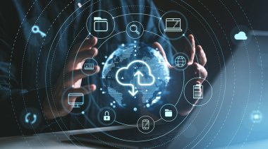 Eller, karanlık bir arkaplanda bulut depolama simgeleriyle dijital bir küreyi kuşatır. Çevrimiçi veri depolama ve güvenliğini temsil eder