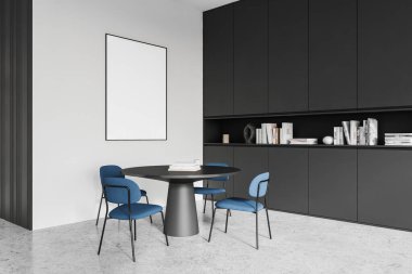 Duvarında boş çerçeveli poster, yuvarlak masa, mavi sandalyeler ve siyah dolaplarla modern iç mekan. Minimalist dekor, basitlik kavramı. 3B Hazırlama