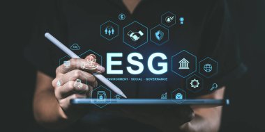 Tablette stilus kullanan el, ESG dijital arayüzü, holografik tarzı, koyu arkaplan. Çevre yönetimi kavramı