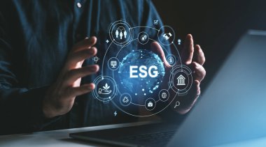 Koyu bir arkaplan üzerinde ESG dijital simgeleriyle etkileşime giren kişi sürdürülebilirlik, sosyal ve yönetim kavramlarını vurgular