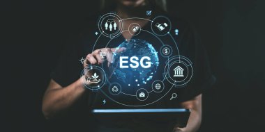 Tabletteki dijital ESG arayüzü ile etkileşime giren kişi. Koyu arkaplan, vurgulama ortamı, sosyal ve yönetim ilkeleri