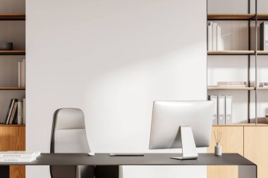 Arkasında boş bir duvar olan modern bir ofis masası, arka planda zarif kitaplıklar ve bir bilgisayar kurulumu. Çalışma alanı modeli kavramı. 3B Hazırlama