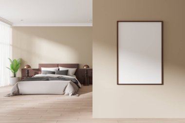 Boş çerçeveli duvar posteri, modern bir yatak odasında bej duvarları ve asgari dekorlu, barışçıl, şık bir iç mekan konsepti sergiliyor. 3B Hazırlama