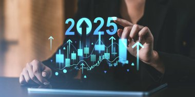 İş kadınının eli gelecekteki 2025 mali grafiklerine işaret ediyor. Veri tabloları ve koyu bulanık arkaplanda maviyle yukarı doğru oklar. Gelecek tahmin ve planlama kavramı