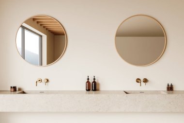 Minimalistic bathroom with two round mirrors, beige stone countertop, and gold wall-mounted faucets, set against a cream-colored wall. 3D Rendering clipart