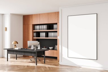 Modern ofis sahnesinde duvarda büyük boş çerçeveli bir poster, bir masa, sandalye, dosyalar ve iyi aydınlatılmış bir yer olan ahşap bir kitaplık var. 3B Hazırlama