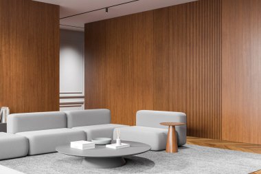 Açık gri kanepeleri, tahta duvar panelleri ve minimalist dekorları olan modern bir oturma odası. Arka plan nötr ve temiz bir atmosferi var. 3B Hazırlama