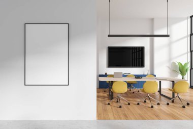 Çağdaş bir ofiste, sarı sandalyeli, ahşap zeminli ve büyük pencereli beyaz bir duvarda çerçevelenmiş boş bir poster modeli. 3B Hazırlama