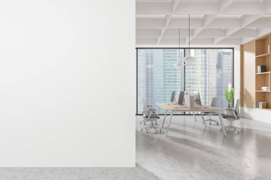 Modern ofis sahnesinde solunda boş beyaz bir duvar ve bilgisayarları, geniş pencereleri ve şehir manzarası olan bir çalışma alanı var. 3B Hazırlama