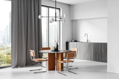 Yuvarlak bir yemek masası, ahşap sandalyeler ve büyük pencereli ve gri perdeli dolapları olan modern bir mutfak. Lüks ev tasarımı kavramı. 3B Hazırlama.