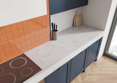 Bright kitchen countertop with a gray surface, orange tile backsplash, and blue cabinets, with a cutting board and knife holder, in a well-lit setting. 3D Rendering. clipart