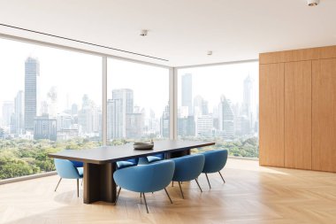 Gösterişli bir masanın etrafında mavi sandalyeler, ahşap duvarlar ve şehir manzarası ve yeşillik sergilenen yerden tavana pencereler olan parlak yemek alanı. Modern zarafet. 3B Hazırlama.