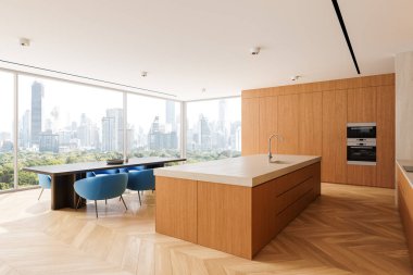 Minimalist mutfak alanı, ahşap dolaplar, ada ve mavi sandalyeler. Parlak şehir manzarası geniş pencerelerden görünüyor. Lüks ev kavramı. 3B Hazırlama.