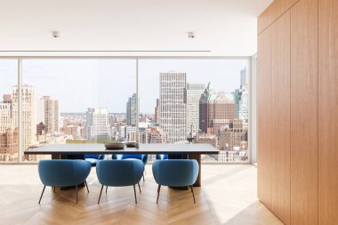 Mavi sandalyeli, ahşap masalı ve minimalist dekorlu zarif bir yemek düzeni. Büyük pencerelerden görünen parlak şehir silueti. Modern iç mekan konsepti. 3B Hazırlama.