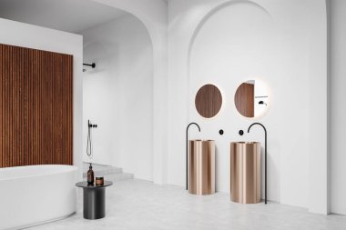 Minimalist banyo içinde altın lavabo, beyaz duvarlarda yuvarlak aynalar, ahşap panel aksanları ve özgür bir beyaz küvet. 3B Hazırlama