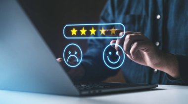 Bir dizüstü bilgisayarın üzerinde parlayan 5 yıldızlı derecelendirme arayüzü ile el etkileşimi, pozitif geri bildirim ve müşteri memnuniyeti kavramı