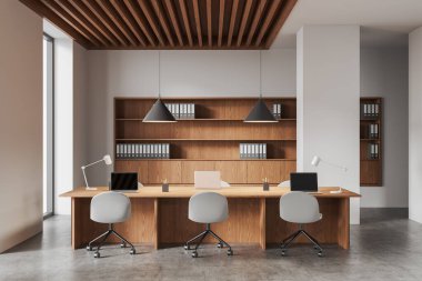 Ahşap masalar, minimalist sandalyeler, klasörlü raflar, kolye ışıkları ve parlak doğal ışıklandırmanın yer aldığı modern bir çalışma odası. İş dünyası kavramı. 3B Hazırlama.