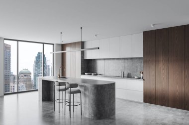 Tabureleri, ahşap ve beyaz dolapları olan beton bir ada ve şehrin ufuk çizgisini gösteren geniş pencereli gösterişli modern mutfak.