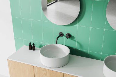 Yuvarlak beyaz lavabosu, musluğu, yeşil fayanslı duvarı ve ahşap dolabı olan modern banyo süsü. Parlak, temiz ve minimalist bir kavram. 3B Hazırlama.
