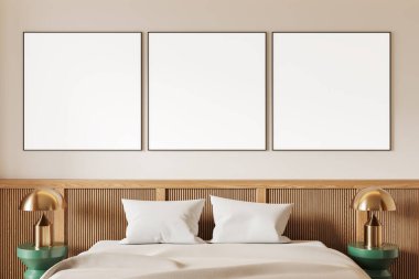 Yatağın üzerinde beyaz yatak örtüsü, altın lambası ve ahşap yatak başlığı olan üç boş çerçeveli poster. Minimalist iç tasarım rahat bir yatak odası düzeninde. 3B Hazırlama.