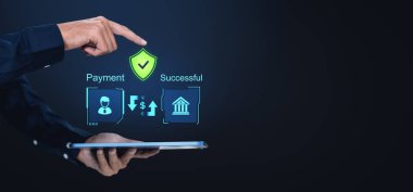 Bir el, Ödeme Başarılı metni bir tabletin üzerinde gösterilen bir kalkan simgesini gösterir. Finansal simgelerle dijital arayüz, koyu arkaplan