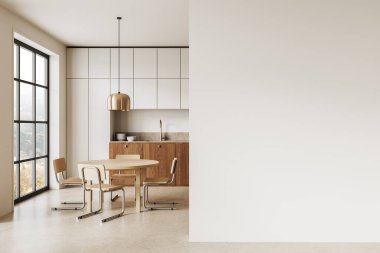 Modern mutfak ahşap mobilyalar, yuvarlak masa, sandalyeler, kolye lambası, geniş pencere ve boş beyaz duvar. İç tasarım görüntüsü kavramı. 3B Hazırlama.