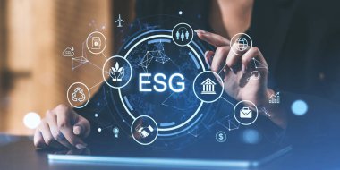 Sürdürülebilirlik ve yönetim simgeleriyle çevrili dijital bir ESG arayüzü ile etkileşimde olan kişi. Gelecekçi stil, bulanık arkaplan, modern konsept
