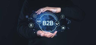 Koyu arkaplanda küresel dijital bağlantıları olan parlayan B2B ağ simgelerini çerçeveleyen eller. İş, teknoloji ve çevrimiçi platform kavramı