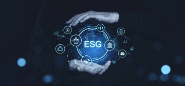 Parlak ESG simgelerini çevreleyen, sürdürülebilirliği, yönetimi ve sosyal sorumluluğu temsil eden bir iş adamının elleri.