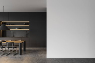 Karanlık dolapları, yemek masası ve boş beyaz bir duvarın yanında sandalyeleri olan modern minimalist bir mutfak. İç tasarım ve yaratıcı düzen kavramı. 3B Hazırlama.