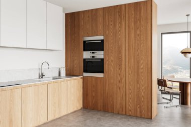 Ahşap dolaplı şık mutfak, beyaz üst depo, gri tezgah, dahili aletler ve geniş pencereli yemek odası. Modern tasarım. 3B Hazırlama.