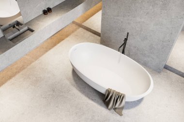 Kenarına havluyla örtülmüş zarif beyaz oval küvet, nötr dokulu arka planda modern bir musluk ile hafif taş döşeme üzerine yerleştirilmiş. 3B Hazırlama