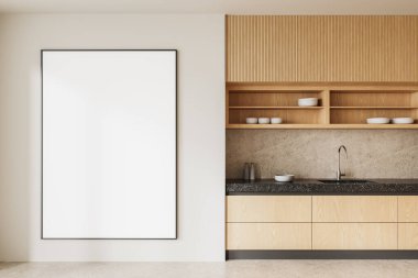 Ahşap dolapları, açık rafları ve taş tezgahı olan minimalist bir mutfak. Temiz bir duvarda büyük boş bir poster çerçevesi. Model gösterisi için mükemmel. 3B Hazırlama.