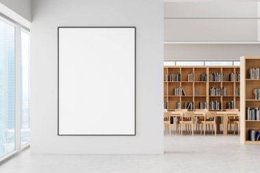 Modern kütüphanenin içinde ahşap kitap rafları ve masalarla dolu temiz beyaz bir duvara kocaman boş bir poster çerçevesi. Büyük pencerelerden gelen parlak doğal ışık. 3B Hazırlama.