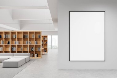 Modern kütüphane içinde duvarda boş çerçeveli poster, ahşap kitaplıklar, kanepeler ve büyük pencereler var. Reklam ya da sunum için temiz alan. 3B Hazırlama.
