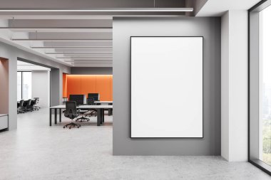 Geniş bir ofis, gri bir duvarda kocaman boş bir poster, modern mobilyalar ve parlak ışıklandırma. Turuncu aksanlı, temiz ve minimalist bir çalışma alanı. 3B Hazırlama.