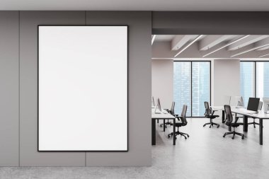 Açık çalışma istasyonları, cam pencereler ve şehir manzaralı, parlak, modern bir ofiste, temiz bir duvarda kocaman boş bir afiş. Minimalist tasarım konsepti. 3B Hazırlama.