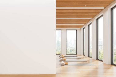 Yoga stüdyosunun içinde yoga minderleri, bloklar ve ahşap zemin silindirleri var. Minimalist tarzda, beyaz duvar arkaplanı. Refah kavramı. 3B Hazırlama