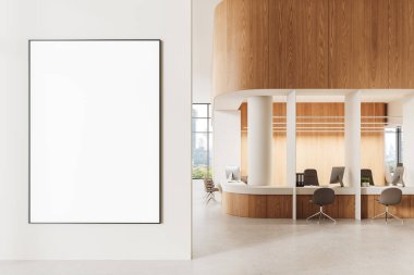 Modern ofis içindeki temiz beyaz duvarda boş çerçeveli poster, ahşap ve nötr tonlar, açık çalışma alanı ve geniş pencereler. Marka konsepti. 3B Hazırlama.