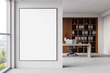 Pencerenin yanındaki ışıklı ofis duvarında büyük çerçeveli boş bir poster. Minimalist çalışma alanı, ahşap raflar, masa ve arka planda sandalye. Temiz tasarım. 3B Hazırlama.