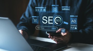 SEO holografik arayüzü, dijital pazarlama, arama motoru optimizasyonu ve çevrimiçi analitiği tasvir eden dizüstü bilgisayar ve akıllı telefon kullanan profesyonel iş adamları